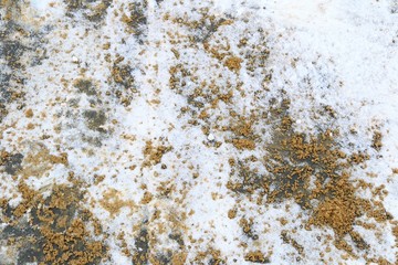 Snow-covered pavement sprinkled with sand. Snow on the pavement. The process of sand spreading allows people to walk safely. Safe sidewalk for pedestrians and animals. No salt