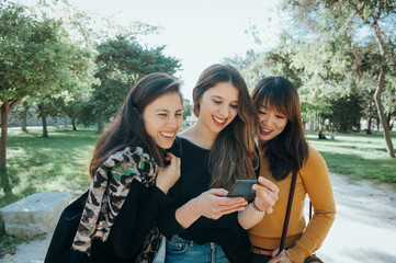 group of three friends talking and walking on the street. 