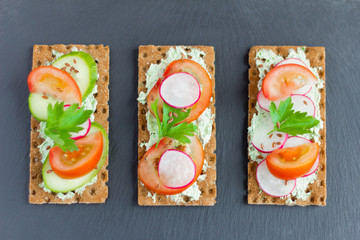 delicious summer sandwiches with cottage cheese with herbs and vegetables,sprinkle with flax seeds on a stone Board