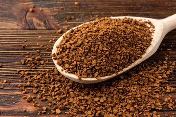 Granulated coffee on dark wooden background.