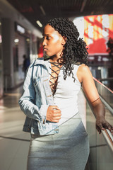 Young dark-skinned woman dressed in casual clothes in the mall