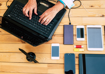 Couple of senior hands write on laptop. Caucasian people working with technology. Wooden table and many devices