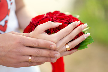 hands with rings on the bouquet