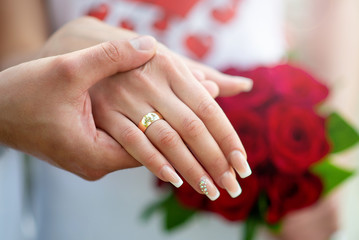 Obraz na płótnie Canvas hands with rings on the bouquet