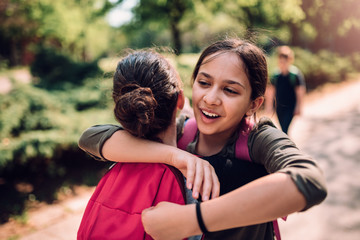 Girlfriends hugging on first day of school