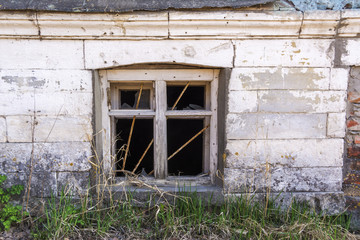 Fototapeta na wymiar Old basement window with broken glass and metal bars.