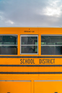 CLose Up Of The Exterior Of A Yellow School Bus Against Cloudy Sky