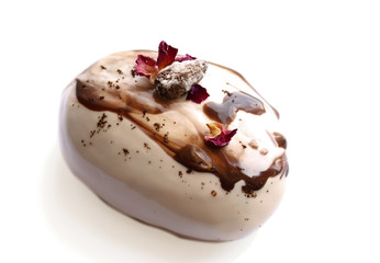 Caramel, coffee and chocolate stone dessert with almonds and rose petals