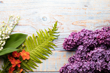  Beautiful flower on a wooden background. Violet lilac, ferns and field flowers.