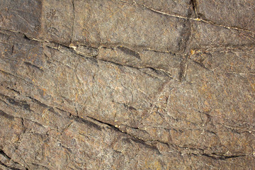 the gray surface of a stone rock with a deep relief. natural texture