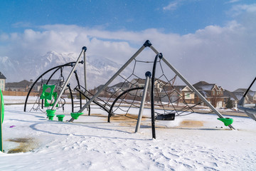 Climbing frames on a playground blanketed with snow on a sunny winter day