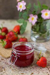Strawberry jam in a glass jar on the table