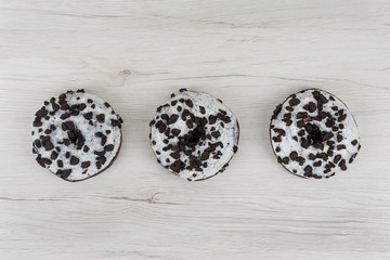 Donuts on a white wood background. Top view, copy space