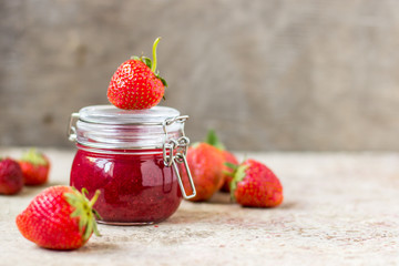 Strawberry jam in a glass jar on the table