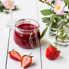 Strawberry jam in a glass jar on the table