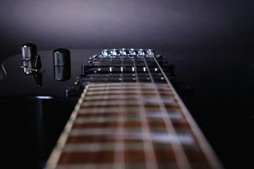 Guitar stringsand fretboard, close up. Electric guitar. .Soft selective focus. On black background