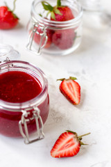 Strawberry jam in a glass jar on the table