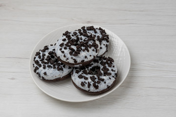 Donuts in a plate on white wood background, close-up
