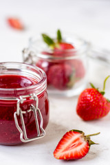 Strawberry jam in a glass jar on the table