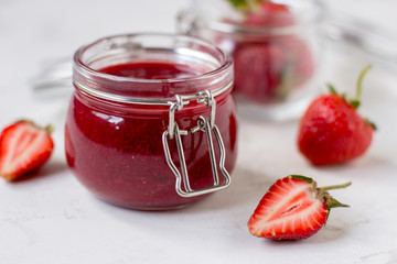 Strawberry jam in a glass jar on the table