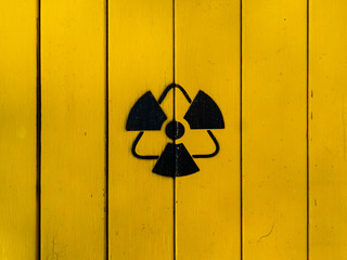 Sign of radiation on a yellow wooden board. Radioactive sign - symbol of radiation. Yellow and...