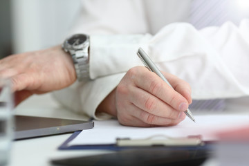 Fototapeta premium Male arm in suit and tie hold silver pen filling schedule in notepad at office workplace closeup. Legal law consult assistance gesture or finance investment advisor clerk job information gesture