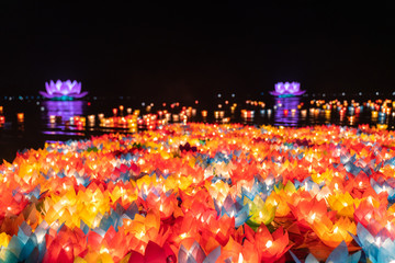 Floating colored lanterns and garlands on river at night on Vesak day for celebrating Buddha's...