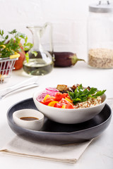 Quinoa salad with roasted eggplant, fresh tomatoes and red onion.   Vegan or vegetarian food. Healthy salad in bowl served on white table.