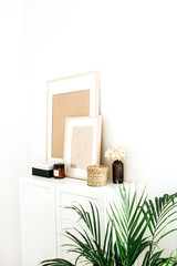Modern minimal Scandinavian nordic interior design. Chest of drawers, photo frames, palm and decorations.