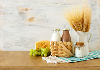 photo of dairy products over wooden table. Symbols of jewish holiday - Shavuot