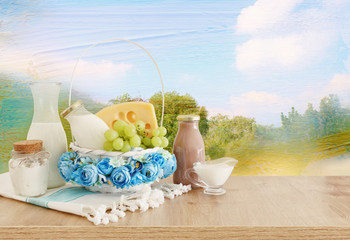 photo of dairy products over wooden table. Symbols of jewish holiday - Shavuot