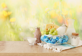 photo of dairy products over wooden table. Symbols of jewish holiday - Shavuot