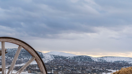 Fototapeta premium Panorama Old fashioned wooden wagon with rusty wheels on a frosted hill in winter