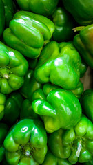 Obraz na płótnie Canvas Vertical closeup image of bell peppers or paprica in store. Texture or pattern of fresh ripe vegetables