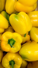 Vertical closeup image of bell peppers or paprica in store. Texture or pattern of fresh ripe vegetables