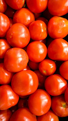 Macro image of lots of red small cherry tomatoes on counter at vegetable store. Texture or pattern of fresh ripe vegetables