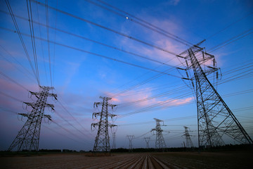 A silhouette of a high voltage tower at sunset
