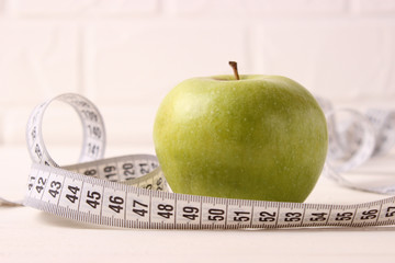 apple and measuring tape on a colored background side view.