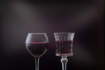 Rose wine. Red wine in two wine glasses over dark background with rays of light