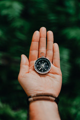 Hand with compass against tropical forest jungle terrain. POV Travel concept © Igor Tichonow