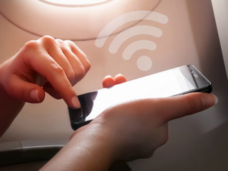 Woman hand using smart phone on the airplane, wifi