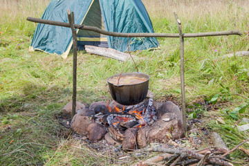 tourist kettle with the cooked food over the burning fire