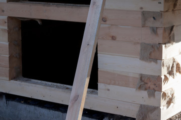 fragment of the wooden house under construction from a bar