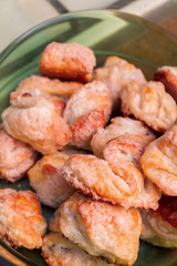 Ready-made cottage cheese biscuits sprinkled with sugar is in a plastic bowl