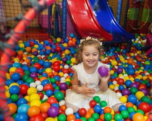 Fototapeta na wymiar Smiling little girl have fun with colorful ball