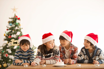 Fototapeta na wymiar サンタ帽を被った子供達とクリスマスツリー