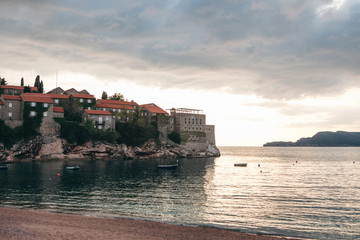 Obraz premium View of the sea and the island of Sveti Stefan on the background of the sunset in Montenegro. This is one of the main attractions of Montenegro.