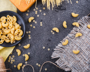 Pasta background. Dry pasta on a black background. Free space for text . Top view