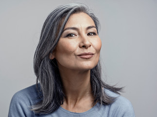 Charming Asian mature woman smiles at camera