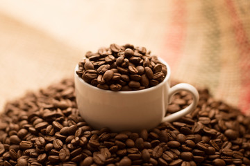 コーヒーカップに入ったコーヒー豆